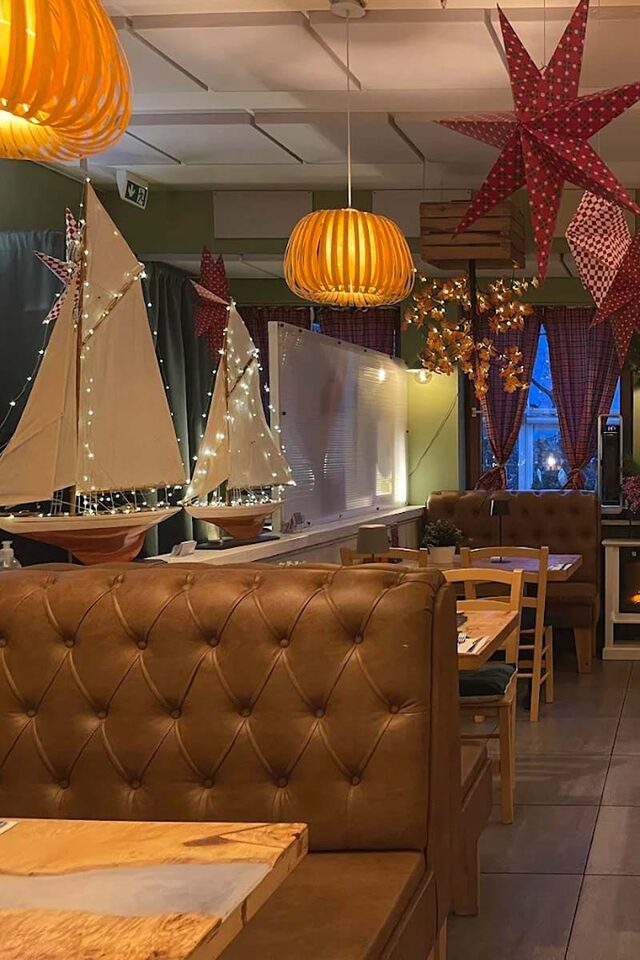 Gastraum der Taverna Pelagos – warmes Holz und Amberlicht